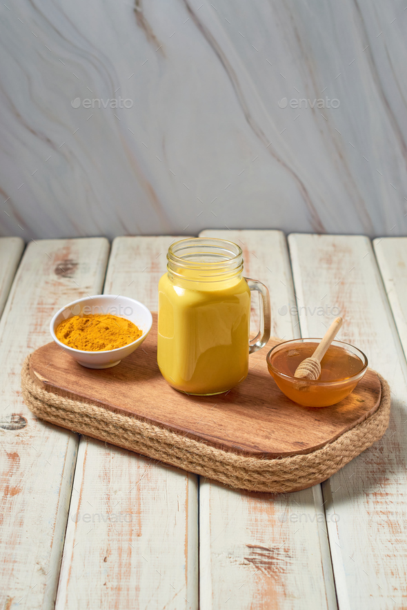 Turmeric latte with milk and honey. Elixir of health and vivacity. Traditional healthy Indian